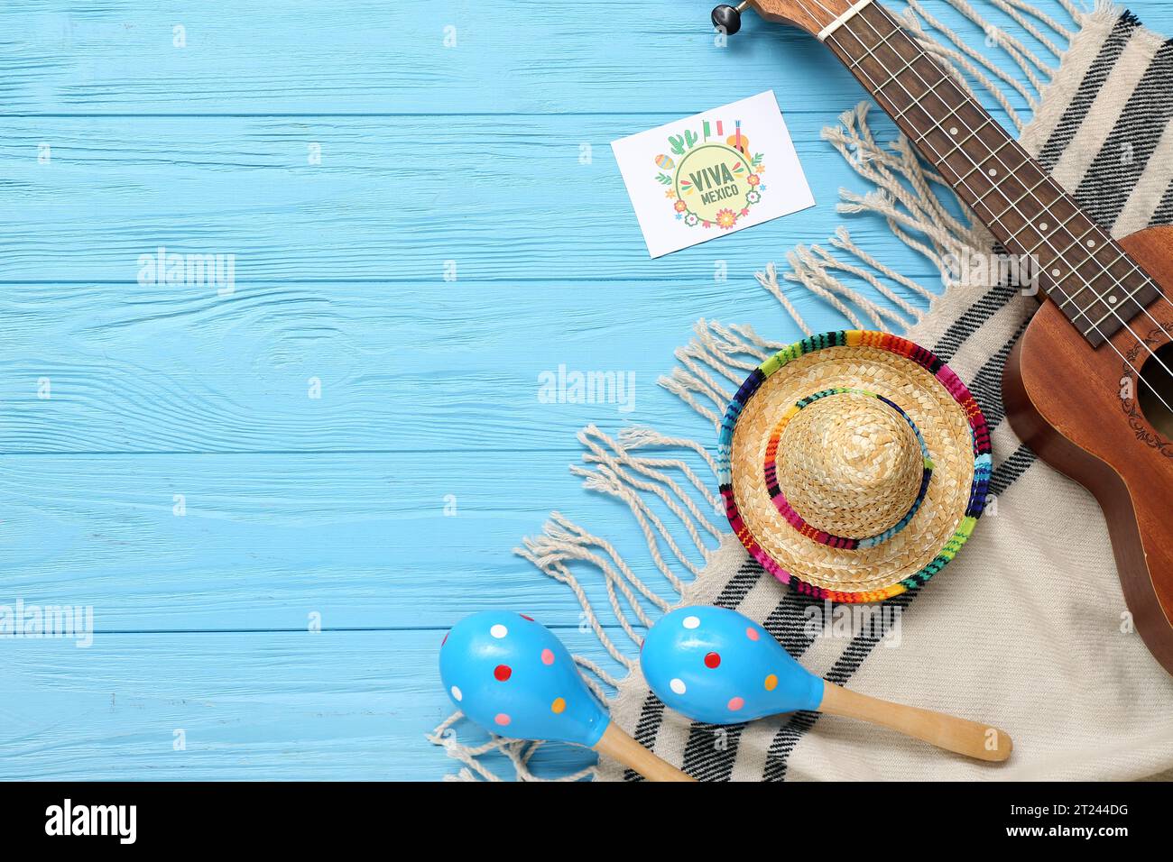 Carte de voeux avec texte Viva MEXICO, maracas, sombrero et ukulele sur fond en bois bleu Banque D'Images