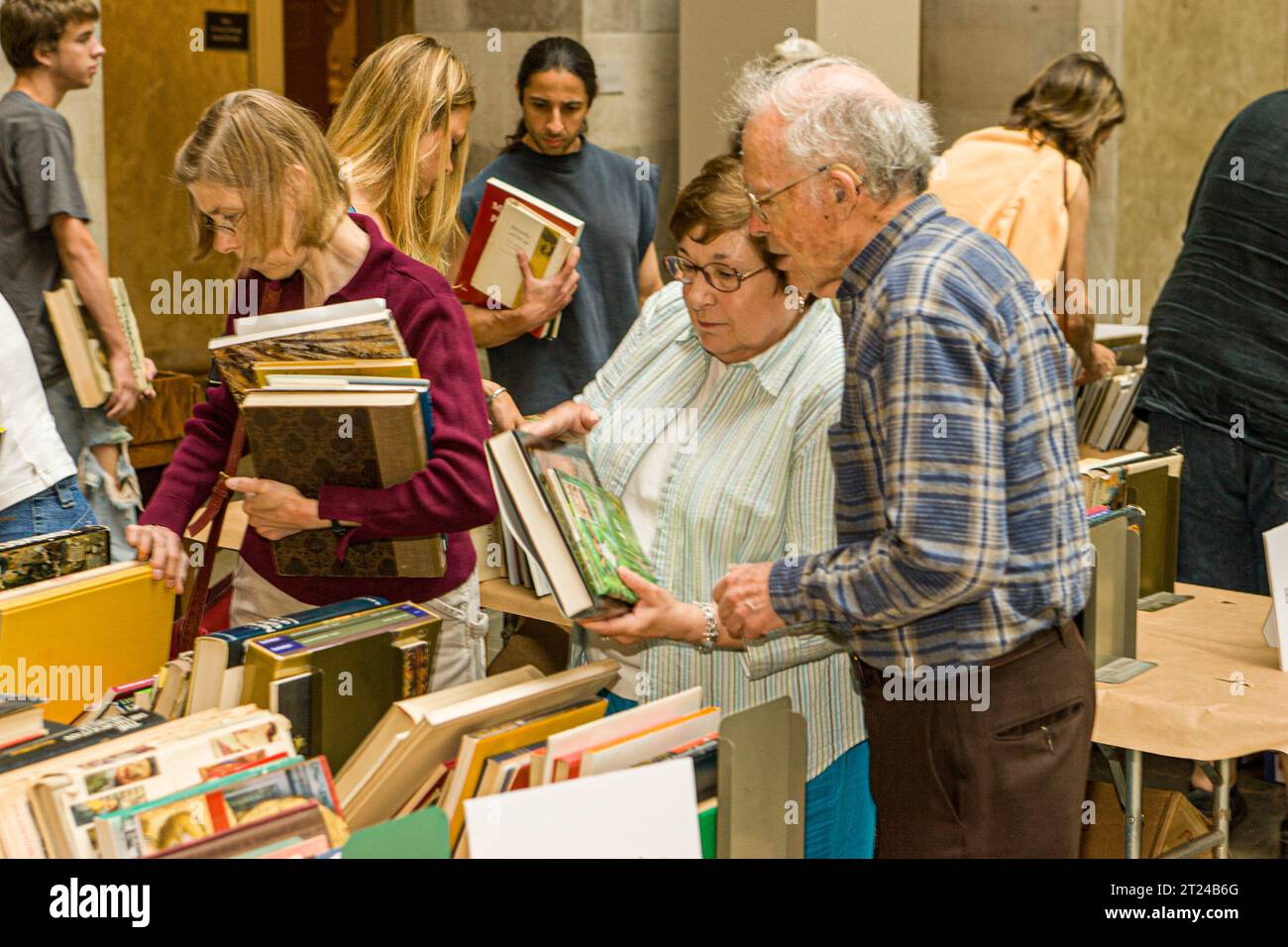 Des gens qui regardent des livres dans une bibliothèque Banque D'Images