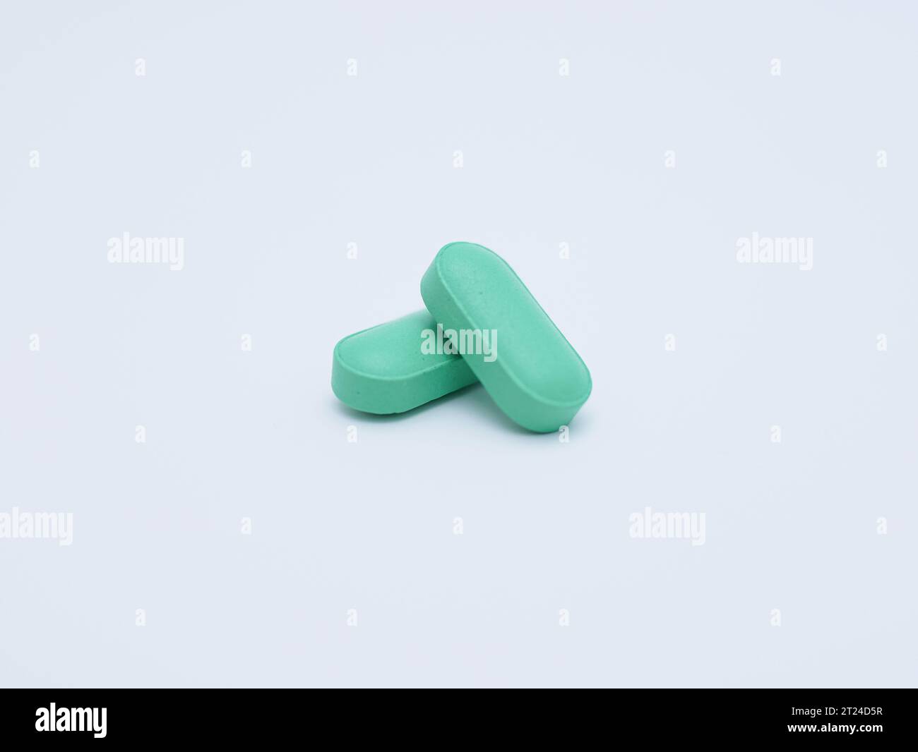 gros plan de deux pilules vertes isolées sur fond blanc Banque D'Images
