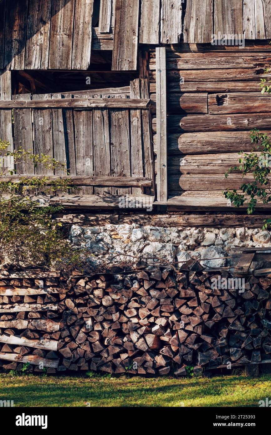 Pile de bois de chauffage à la maison de ferme alpine, image verticale Banque D'Images