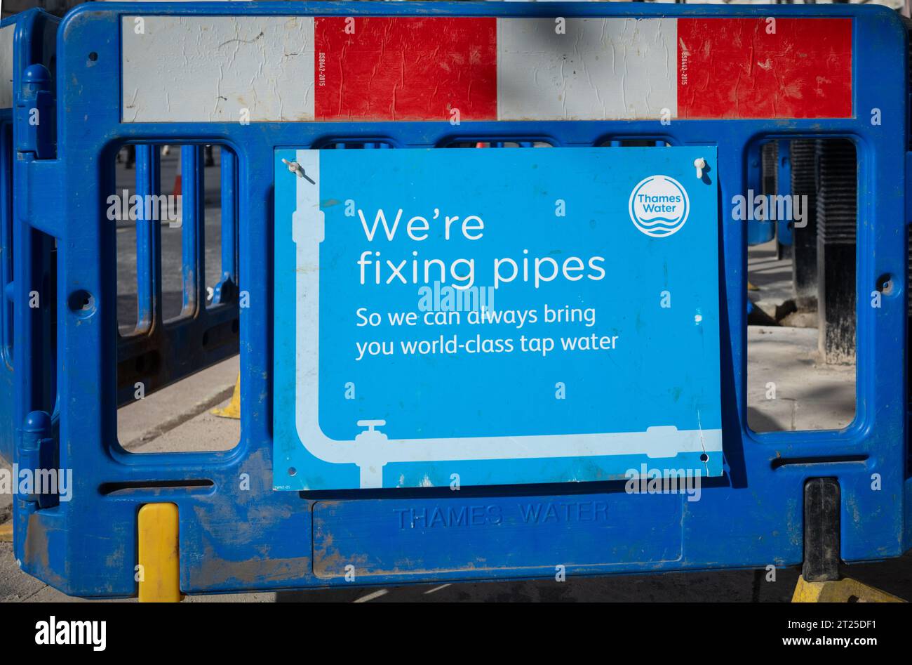 Un panneau à côté d'un trou dans le sol de la société Thames Water Supply indiquant « nous réparons les tuyaux afin que nous puissions toujours vous apporter de l'eau de classe mondiale ». Londres Banque D'Images