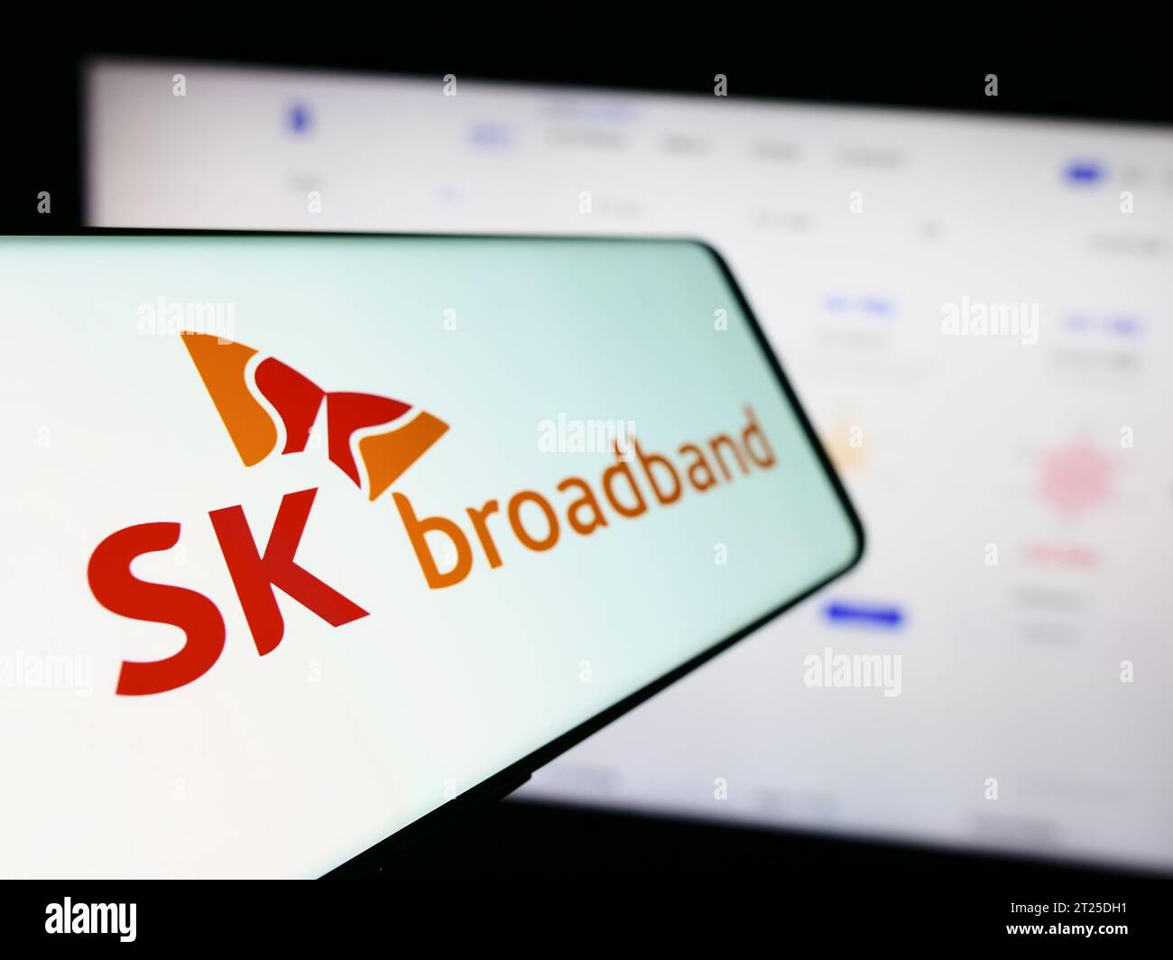 Téléphone mobile avec logo de la société coréenne de télécommunications SK Broadband Inc. Devant le site Web de l'entreprise. Effectuez le focus sur la gauche de l'écran du téléphone. Banque D'Images