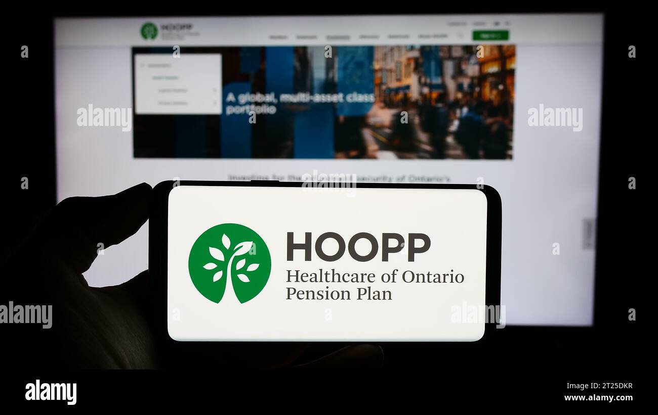 Personne détenant un téléphone cellulaire avec le logo de Healthcare of Ontario Pension Plan (HOOPP) devant la page Web de l'entreprise. Concentrez-vous sur l'affichage du téléphone. Banque D'Images