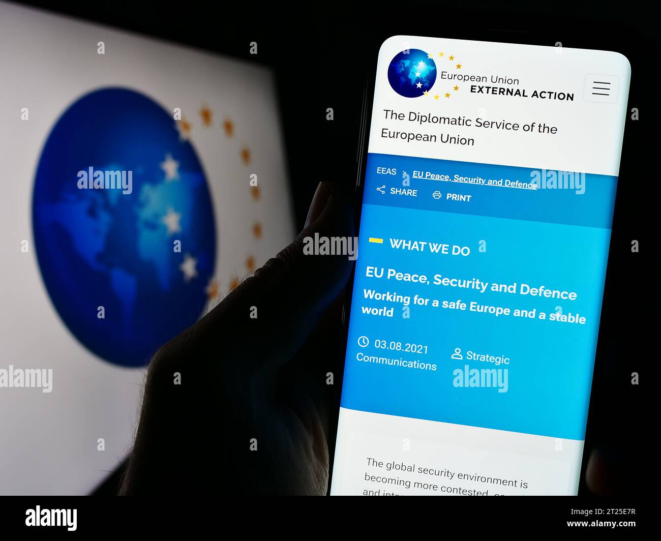 Titulaire d’un téléphone portable portant le site Internet d’une institution de l’UE Service européen pour l’action extérieure (SEAE) avec logo. Concentrez-vous sur le centre de l'écran du téléphone. Banque D'Images