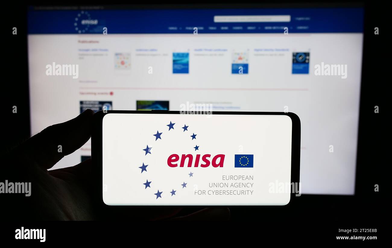 Personne détenant un smartphone portant le logo de l’Agence de l’Union européenne pour la cybersécurité (ENISA) devant le site Internet. Concentrez-vous sur l'affichage du téléphone. Banque D'Images
