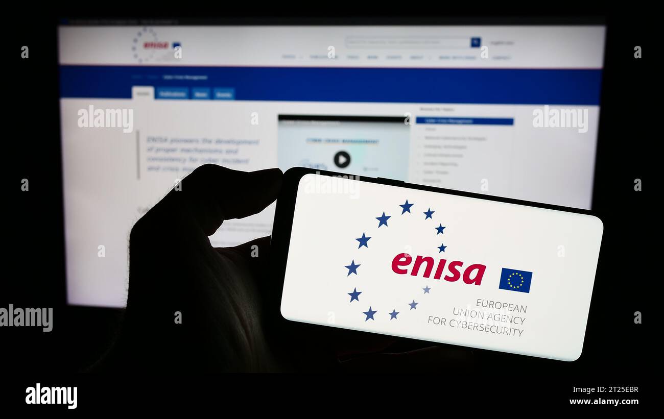 Personne détenant un téléphone portable portant le logo de l’Agence de l’Union européenne pour la cybersécurité (ENISA) devant la page web. Concentrez-vous sur l'affichage du téléphone. Banque D'Images