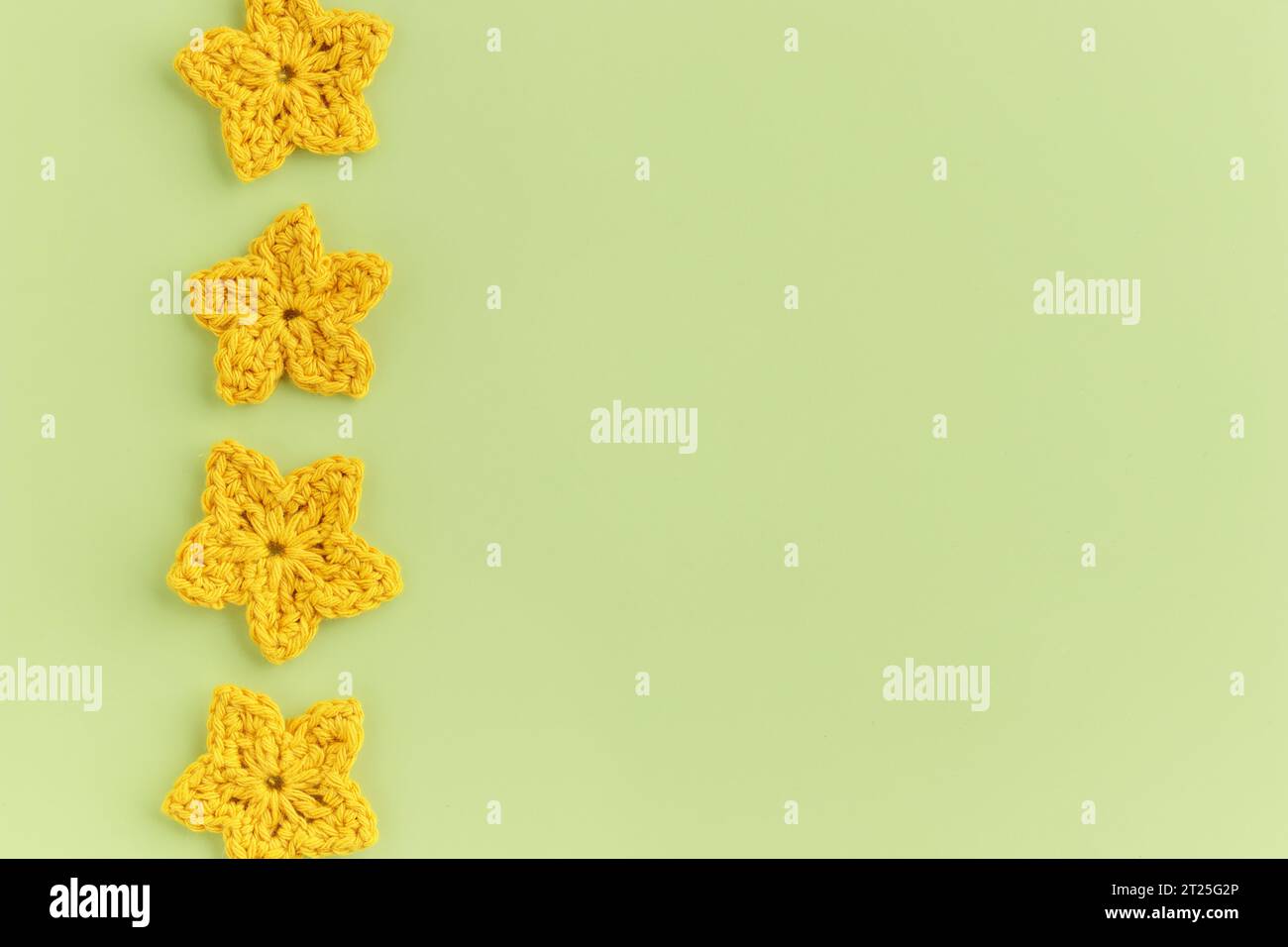 Motif de rangée de fleurs crochetées jaunes sur un fond vert Banque D'Images
