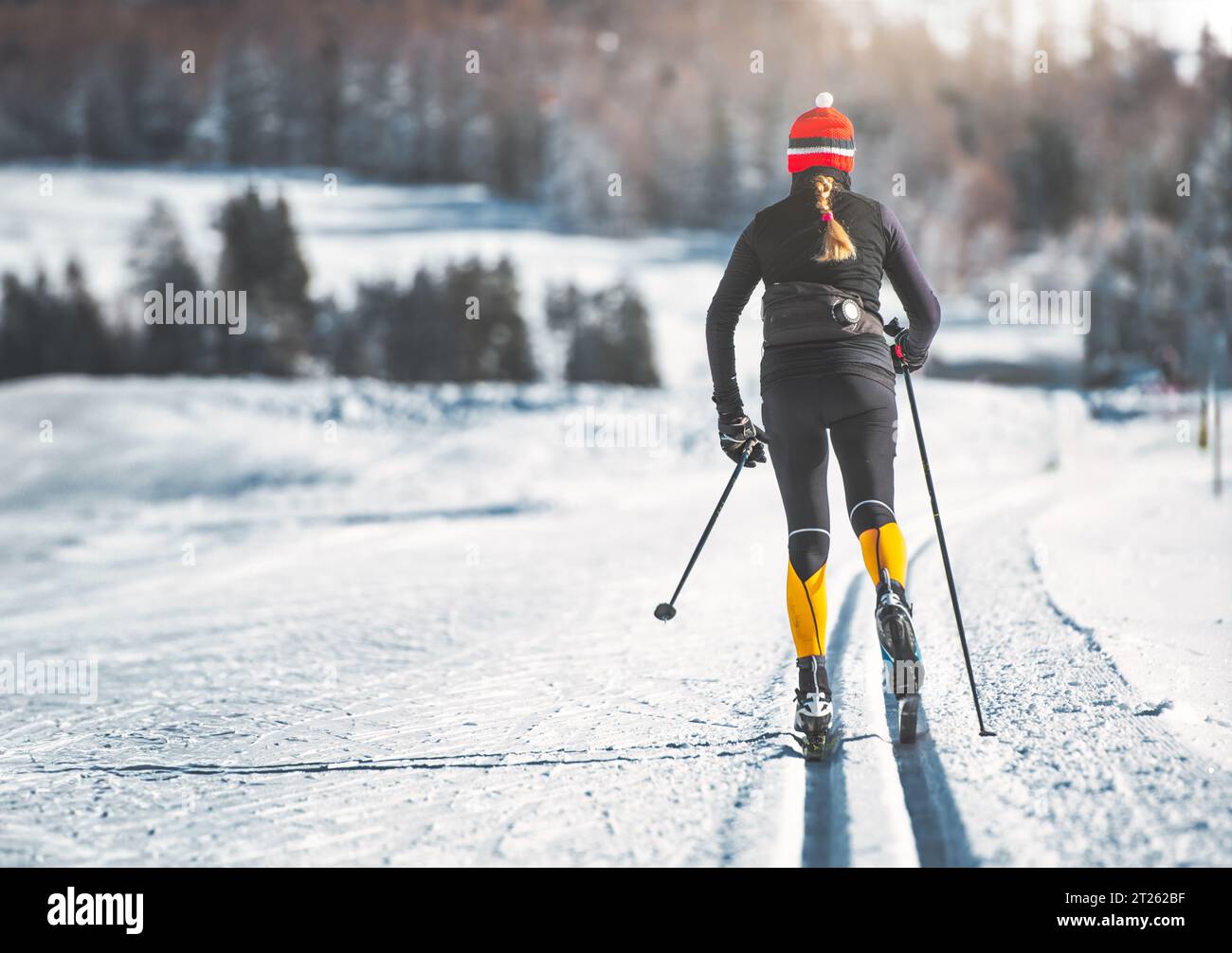 Jeune femme pratique le ski de fond en technique classique Banque D'Images