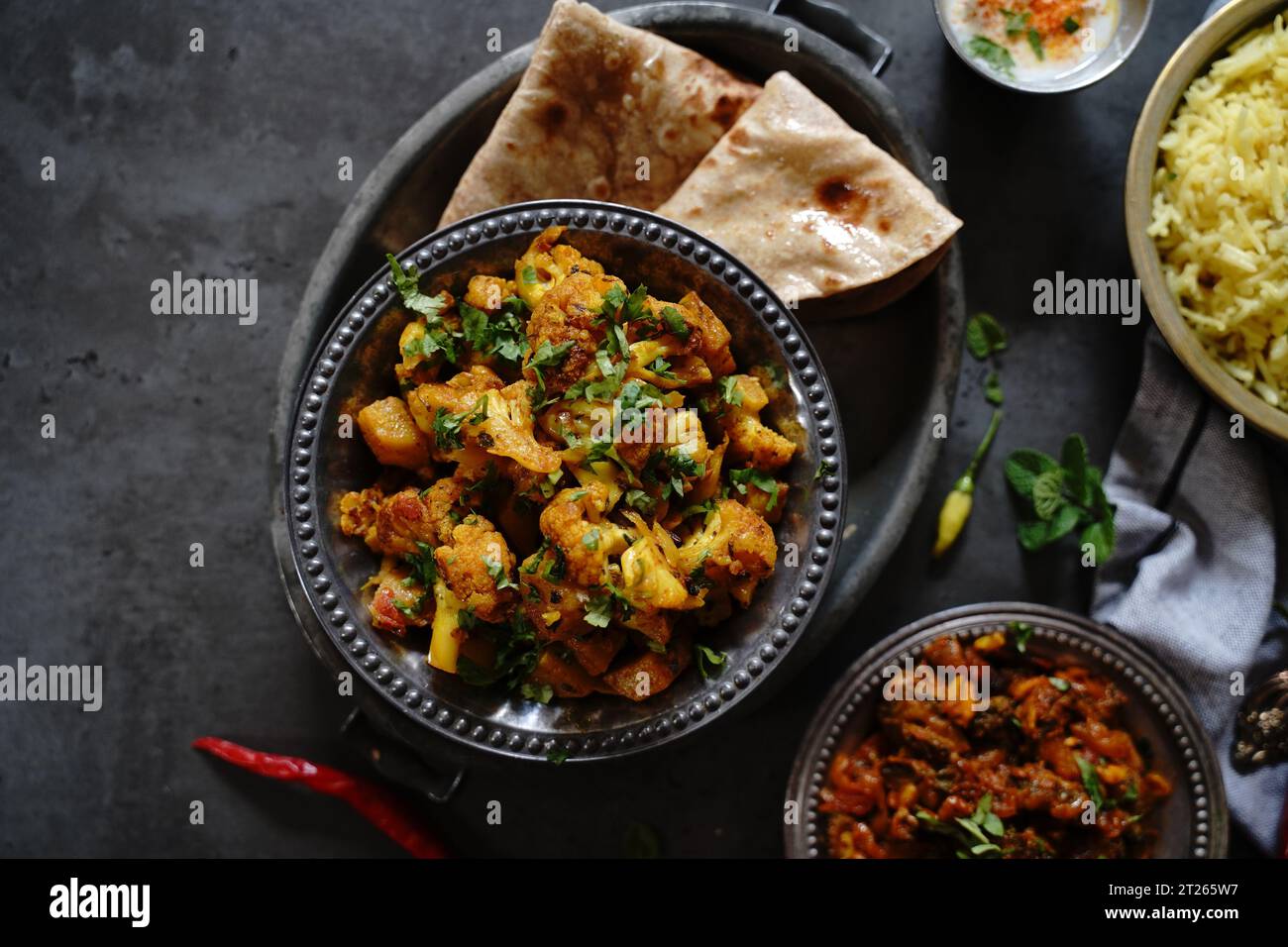 L'aloo Gobi fait maison est un curry végétarien indien composé de pommes de terre et de chou-fleur, servi avec du riz et des roti Banque D'Images