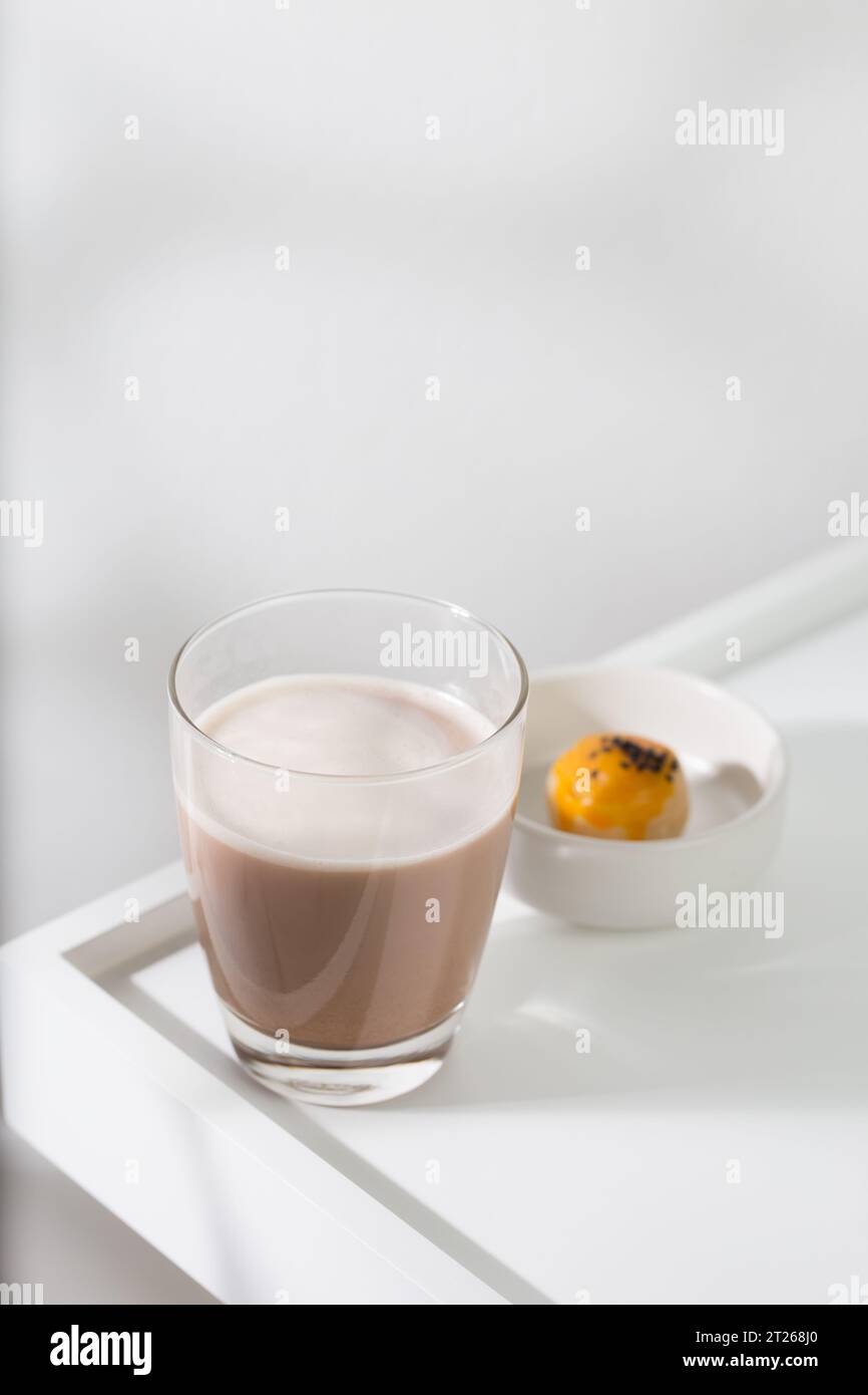 Cacao chaud dans un verre transparent sur une table en bois blanc. Banque D'Images