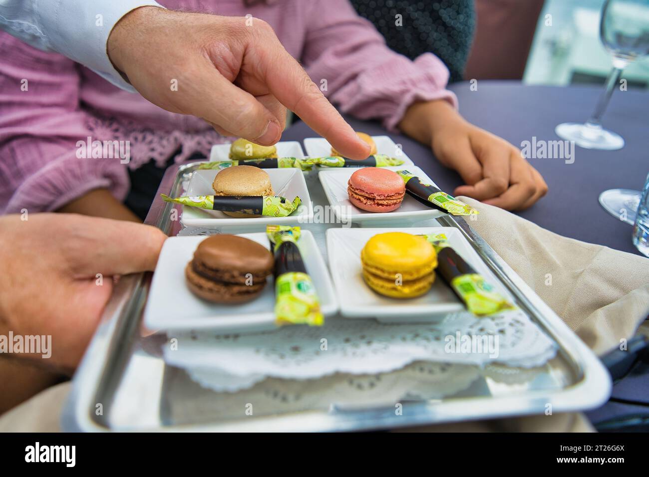 Serveur montrant les sélections de macarons sur les Bateaux Parisiens sur la seine Banque D'Images