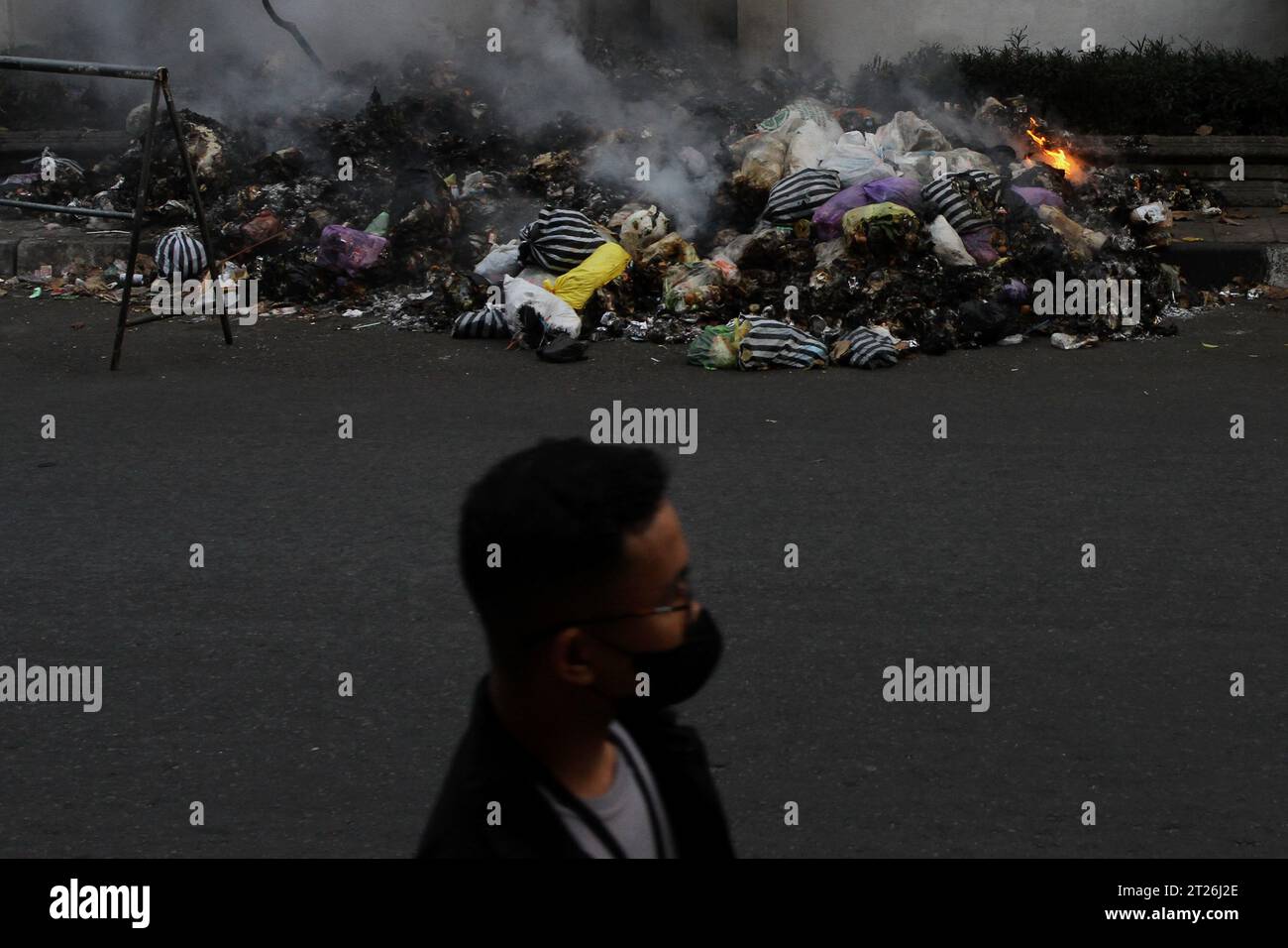 17 octobre 2023, Yogyakarta, région spéciale de Yogyakarta, Indonésie : un homme marche près des ordures brûlantes sur le bord de la route à Yogyakarta. (Image de crédit : © Angga Budhiyanto/ZUMA Press Wire) USAGE ÉDITORIAL SEULEMENT! Non destiné à UN USAGE commercial ! Banque D'Images