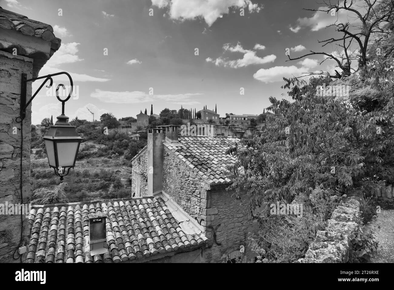 Sur le chemin sur un chemin envahi à Gordes avec une vue sur les vieilles maisons en pierre typiques. Banque D'Images