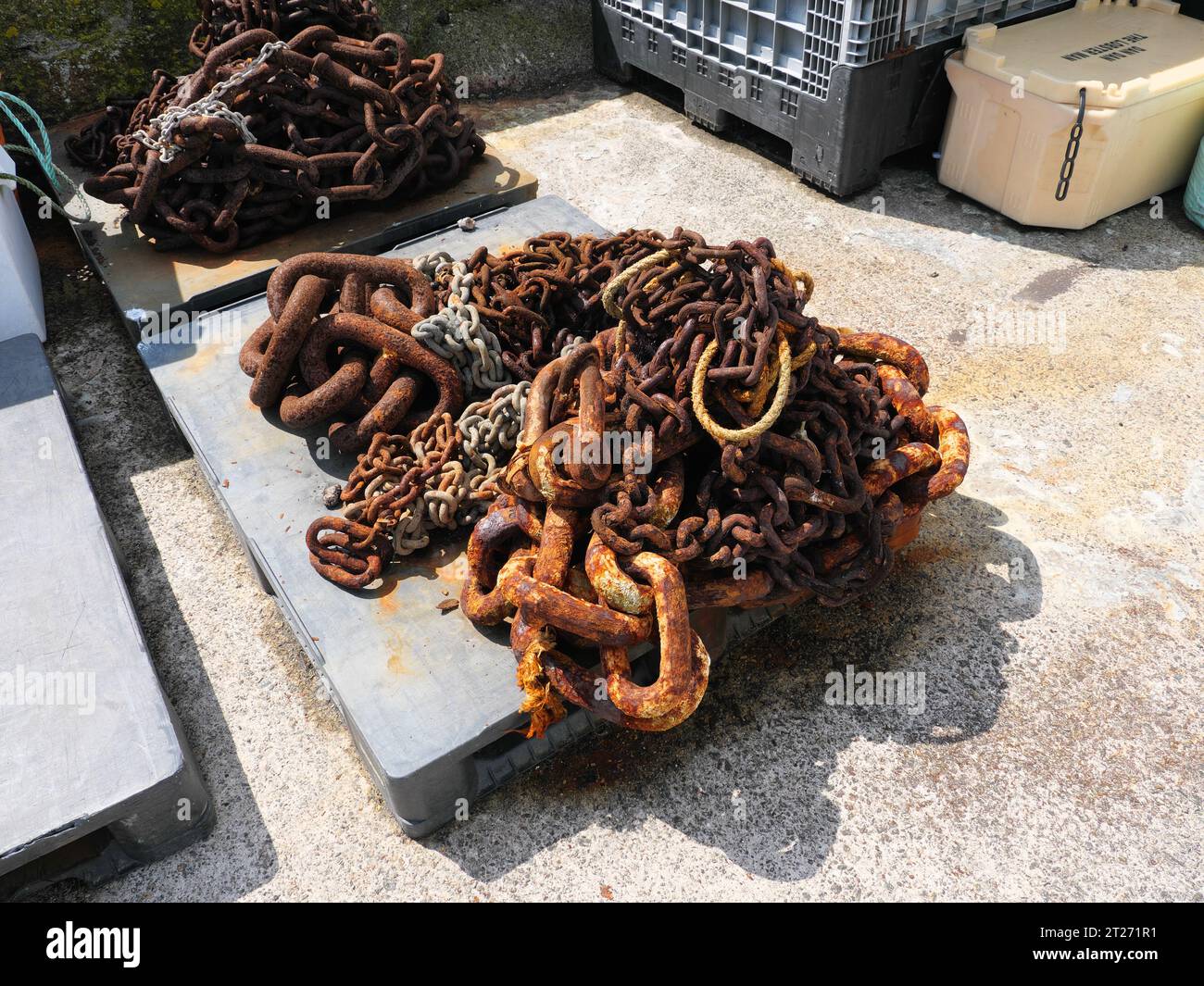 Chaînes rouillées pour l'amarrage des bateaux de pêche dans le port de Porthleven en Cornouailles Angleterre Banque D'Images