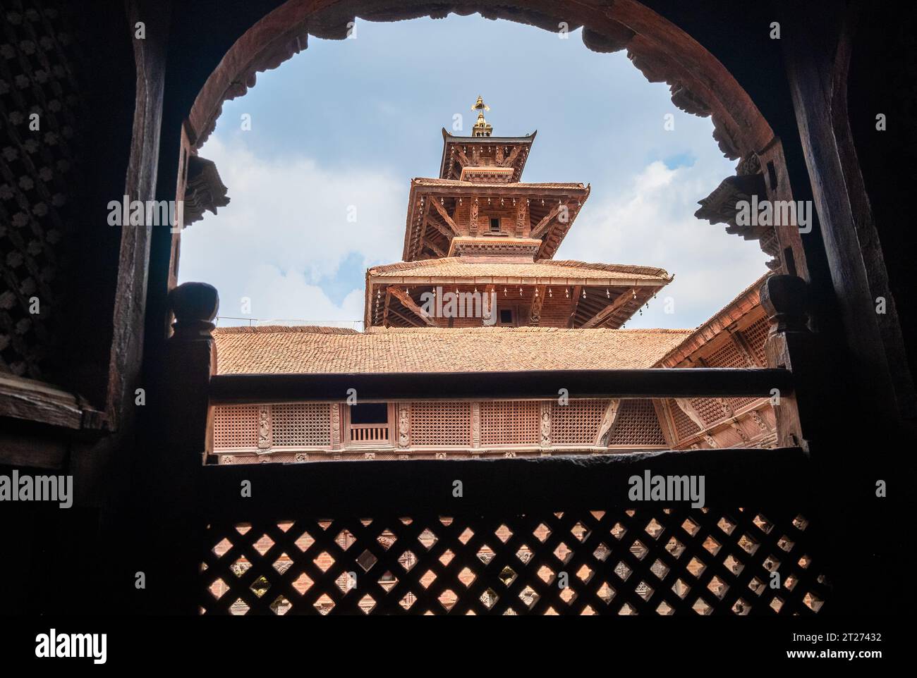 Véritable chef-d'œuvre d'architecture vue sur le vieux temple à travers la fenêtre en bois sculpté, Patan Durbar Square palais royal médiéval et site du patrimoine mondial de l'UNESCO Banque D'Images