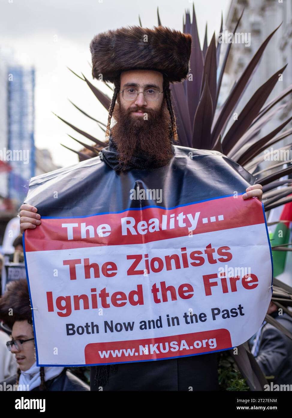 Un manifestant juif orthodoxe tient une bannière de protestation anti-sioniste lors de la marche pro-palestinienne dans le centre de Londres - 14/10/2023. Regarder la caméra. Banque D'Images