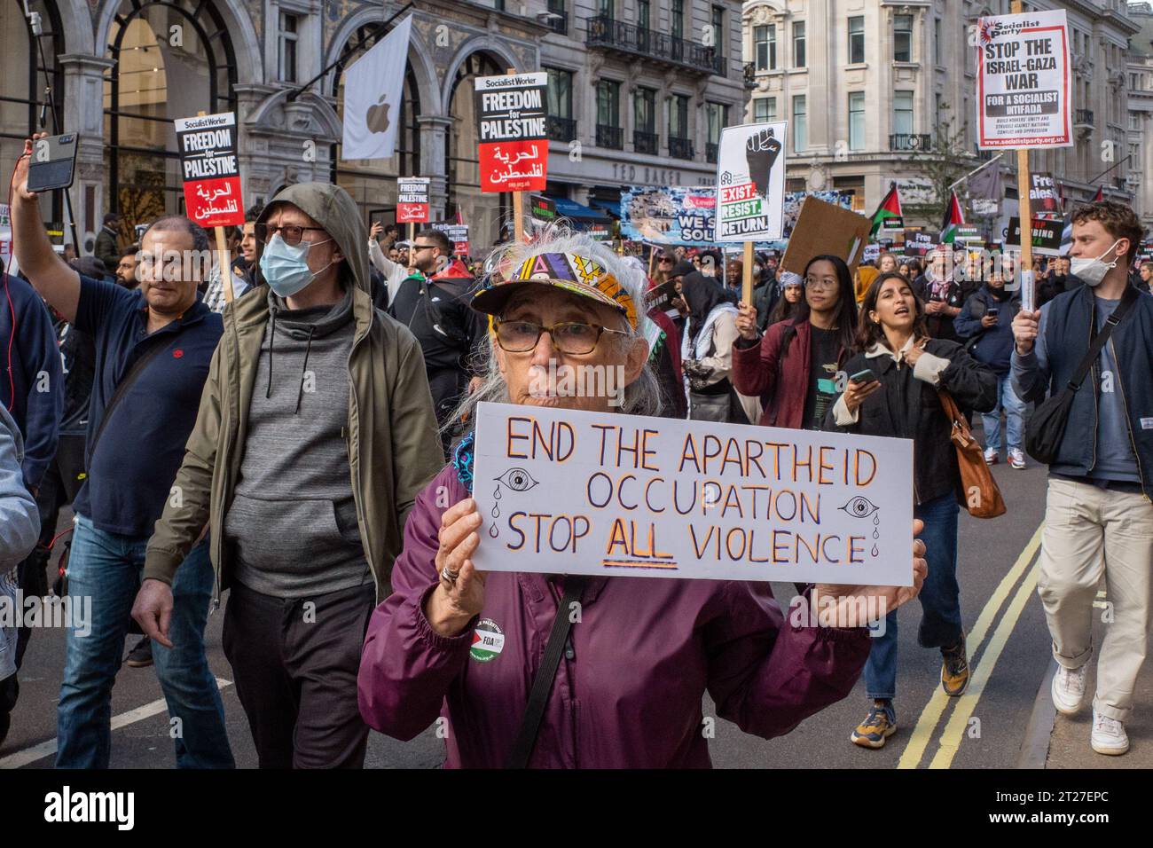 Une femme marche à travers le centre de Londres lors de la manifestation Free Palestine en brandissant une bannière de protestation « End the apartheid, Occupation', octobre 2023. Banque D'Images
