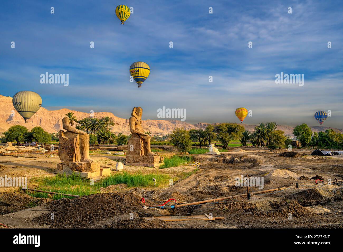 Des montgolfières survolent les statues colossales du nouvel Amenhotep III à Kom El Hitan près du deuxième pylône du temple mortuaire d'Amenhotep III Banque D'Images