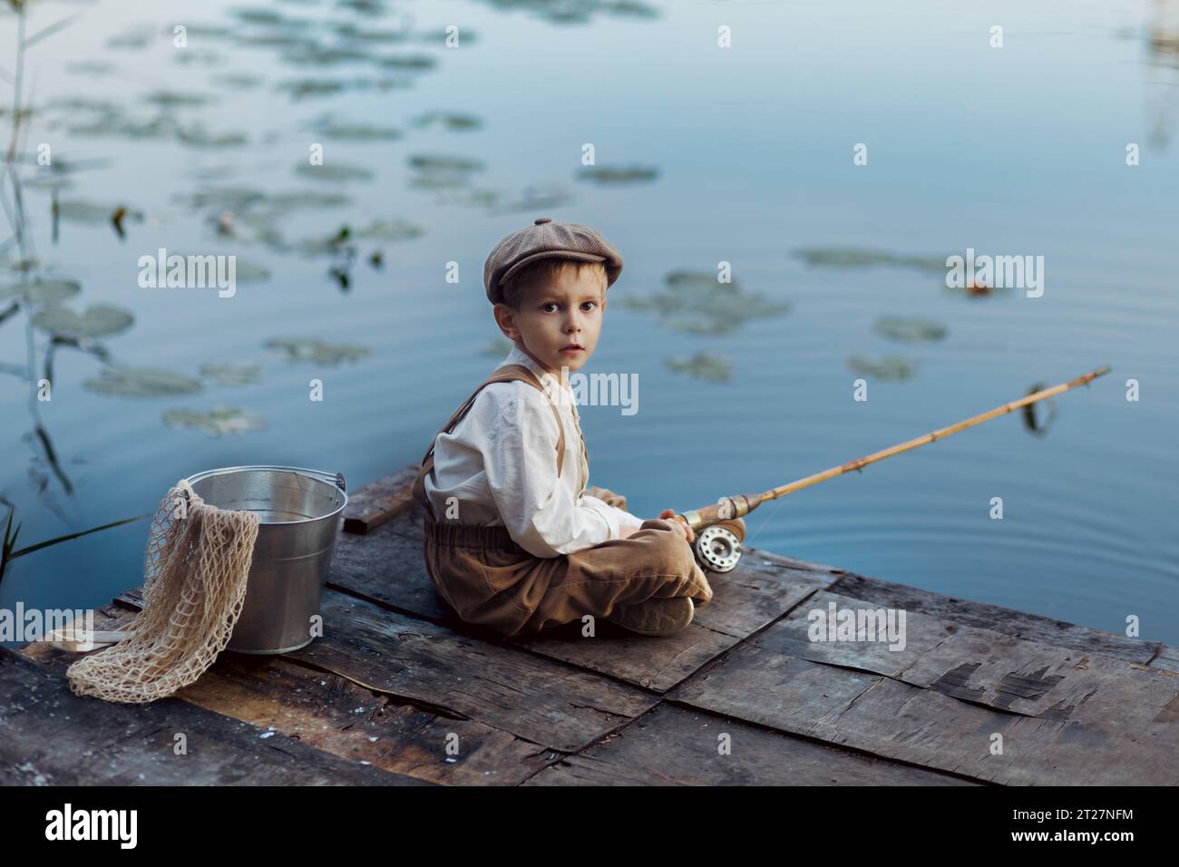 Enfant avec canne à pêche. Pêche enfant au lac d'automne Banque D'Images