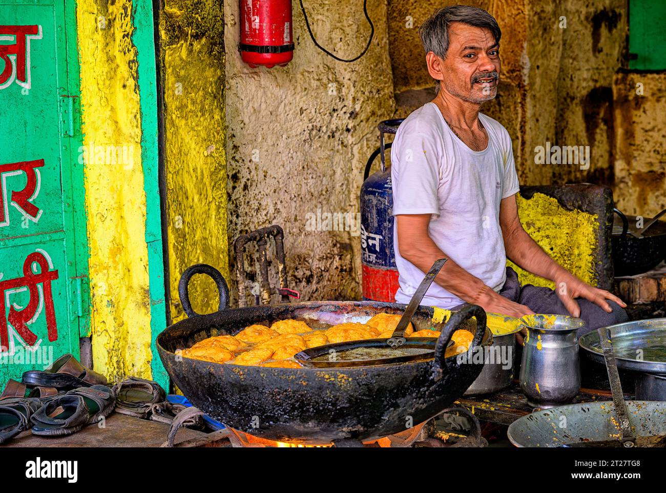 Vendeur de rue sur la vieille route de la tour de l'horloge à Jodhpur cuisinant aloo vada, la populaire nourriture de rue indienne Banque D'Images