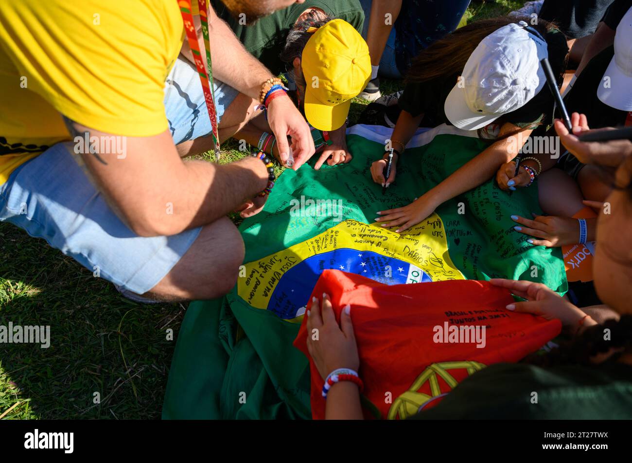 Pèlerins signant un drapeau brésilien en souvenir. Cérémonie d'ouverture des Journées mondiales de la Jeunesse 2023 à Lisbonne, Portugal. Banque D'Images
