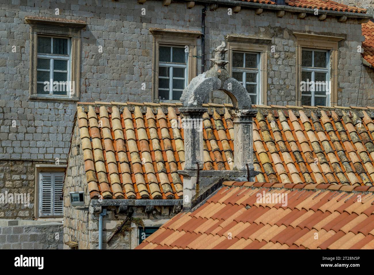 Vue depuis le mur de la ville promenade des toits de tuiles et un vieux clocher dans la vieille ville de Dubrovnik dans le sud de la Croatie. Banque D'Images