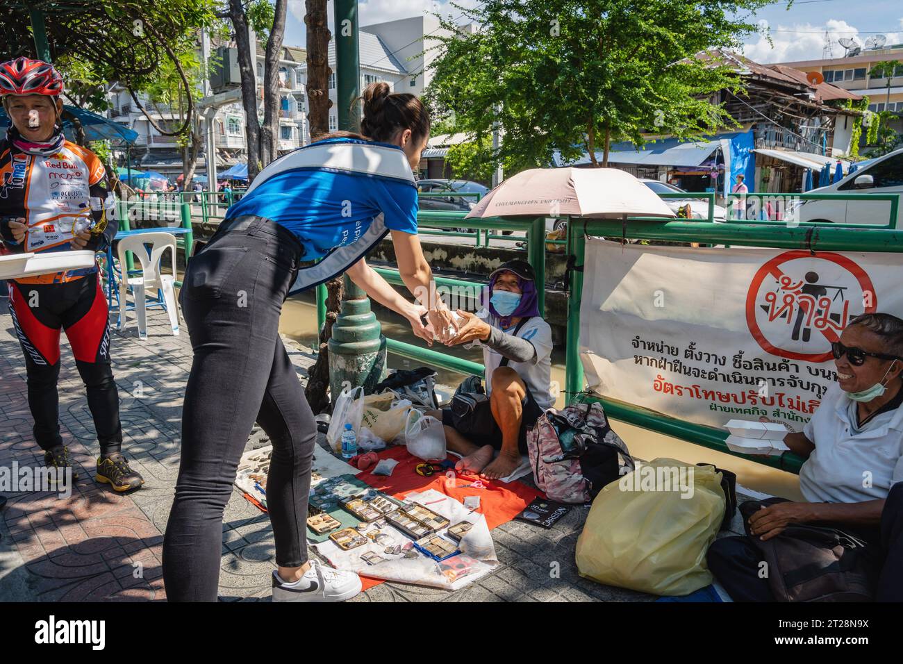Bangkok, Thaïlande. 14 octobre 2023. Miss Thaïlande monde 2023, Tharina Botes distribue des repas gratuits à des citoyens thaïlandais à faible revenu avec la fondation Bangkok Community Help, à la communauté de Trok Sake, à Bangkok. Miss Thailand World 2023, Tharina Botes, d’origine mixte thaï-sud-africaine, a rejoint en tant que bénévole un don de repas gratuits pour les sans-abri et les personnes à faible revenu, organisé par la Bangkok Community Help Foundation, à Bangkok, en Thaïlande. Crédit : SOPA Images Limited/Alamy Live News Banque D'Images