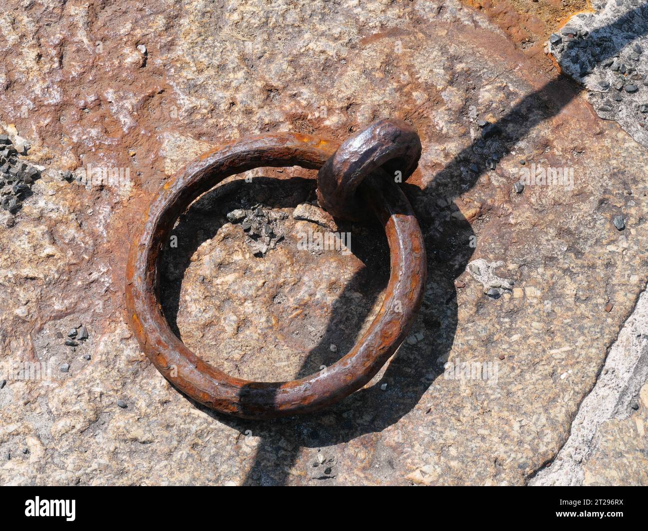 Anneau rouillé utilisé pour attacher une corde d'amarrage de bateau dans le port de Mousehole, Cornouailles Angleterre Banque D'Images