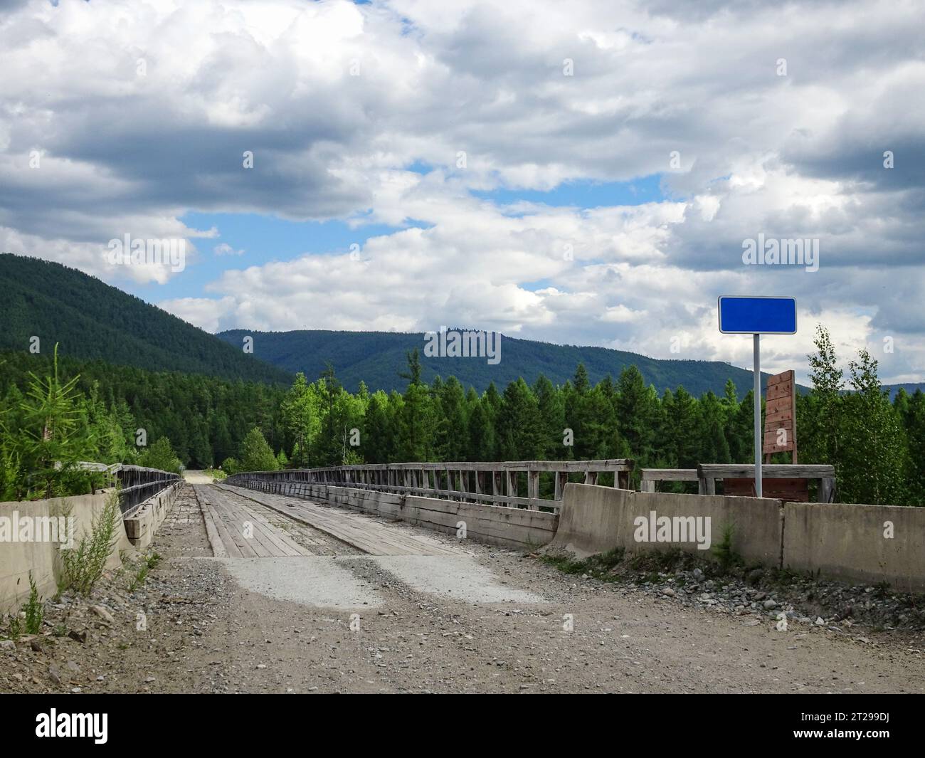 Un ancien pont en bois sur une rivière dans les montagnes, dans une zone peu peuplée. Banque D'Images