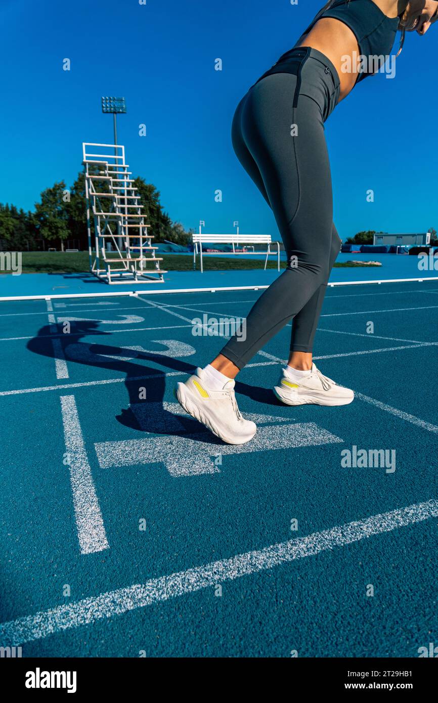 Belle jeune femme bronz?�e, pr?�par?�e et souriante avec une attitude positive pour faire un sprint 