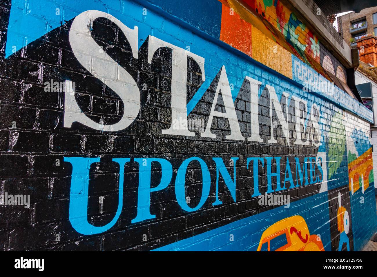 Une fresque colorée célébrant Staines-upon-Thames sur un mur de briques sous un pont ferroviaire sur la High Street à Staines. Banque D'Images