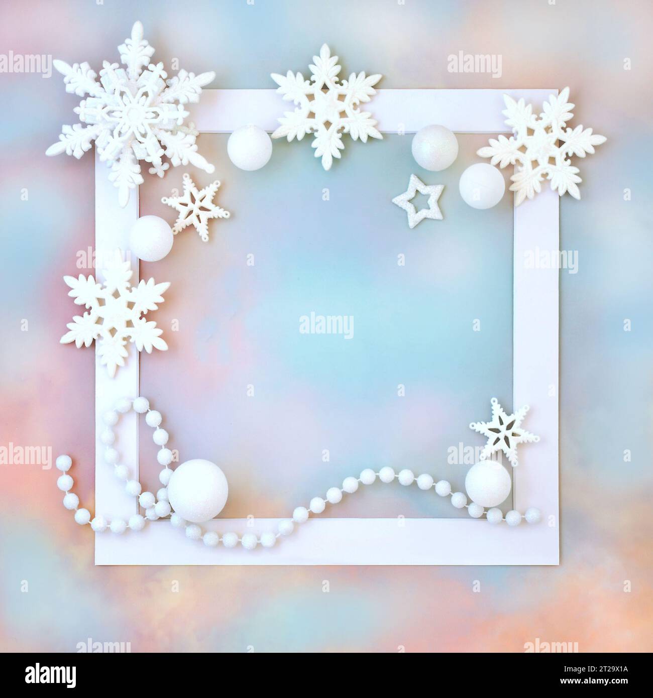 Décoration d'étoile de flocon de neige blanc de Noël et de boule sur cadre blanc sur fond de ciel arc-en-ciel. Motif fantaisie abstrait festif du pôle nord. Banque D'Images