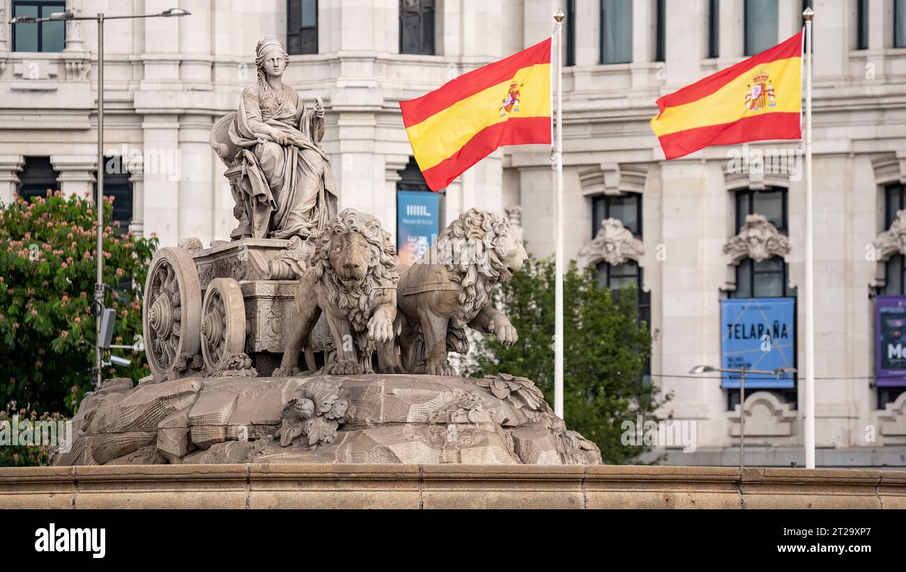 Madrid, Espagne ; 10-16-2023 : statue sur la Plaza de Cibeles avec la représentation de la déesse du même nom et deux lions avec drapeaux espagnols wav Banque D'Images