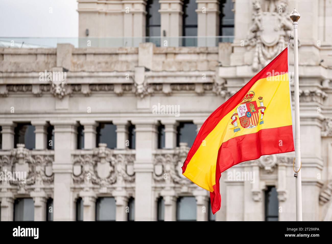 Drapeau de l'Espagne volant dans le vent devant le bâtiment de la mairie de Madrid Banque D'Images