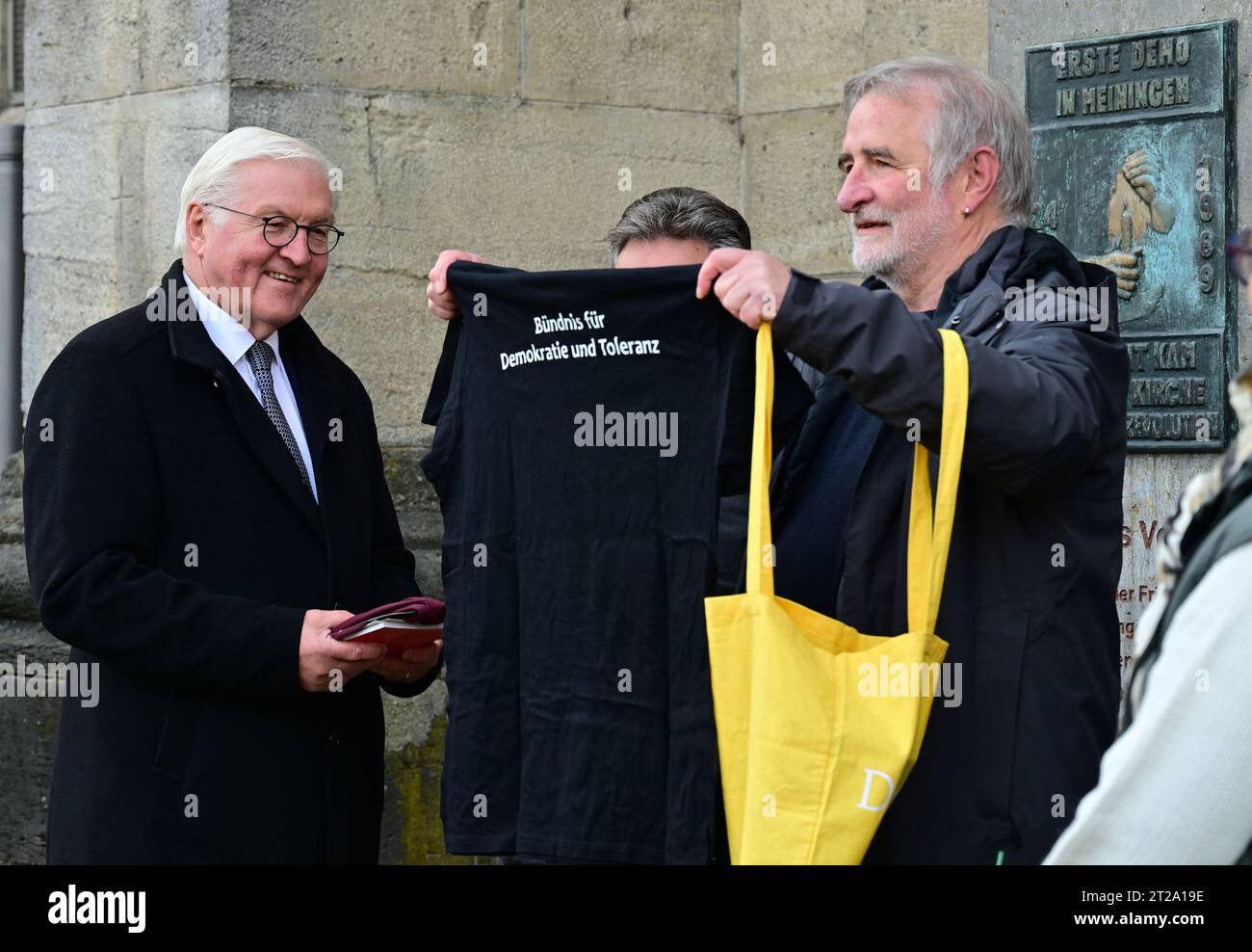 Meiningen, Allemagne. 18 octobre 2023. Le président fédéral Frank-Walter Steinmeier (l) parle à côté d'une stèle commémorative de la Révolution pacifique avec des acteurs de l'Alliance pour la démocratie et la tolérance. Steinmeier a déménagé sa résidence officielle à Meiningen pendant trois jours dans le cadre de « l'heure locale en Allemagne ». Les arrêts en dehors de Berlin sont destinés à engager une conversation avec les citoyens sur les défis, les souhaits et les préoccupations actuels. Crédit : Martin Schutt/dpa/Alamy Live News Banque D'Images