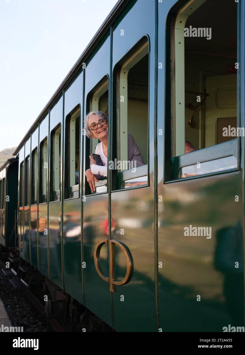 Passager regardant par la fenêtre du train historique du Douro circulant entre Régua et Tua en suivant le fleuve Douro, Portugal, Europe Banque D'Images