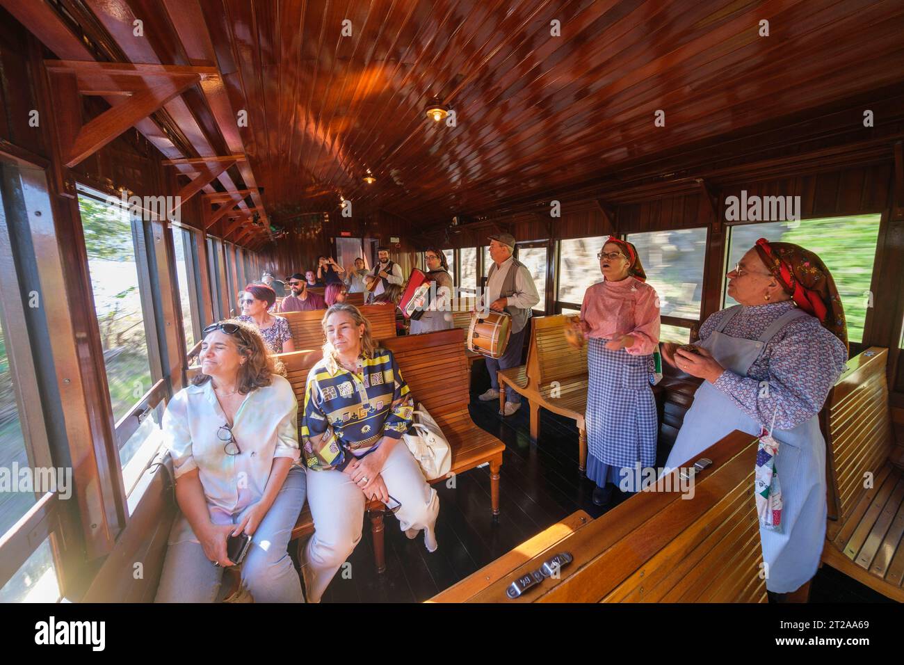 Les gens en vêtements traditionnels chantent à l'intérieur du train historique du Douro qui circule entre Régua et Tua en suivant le fleuve Douro, Portugal, Europe Banque D'Images