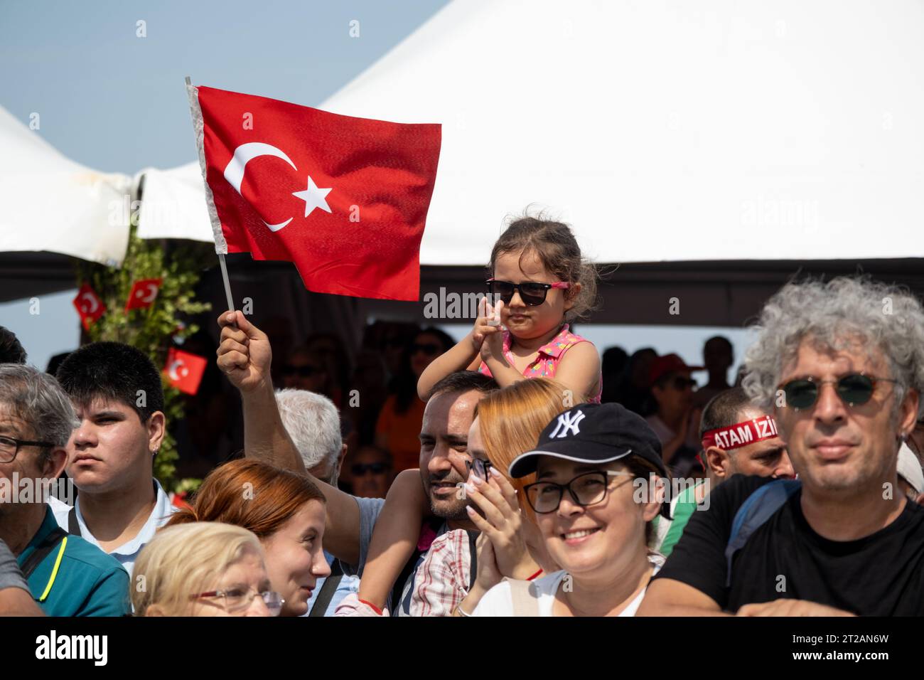 Izmir, Turquie, le 9 septembre 2023 : un moment réconfortant capturant une fillette de 8 à 9 ans avec des lunettes de soleil, perchée sur les épaules de son père, agitant le Banque D'Images