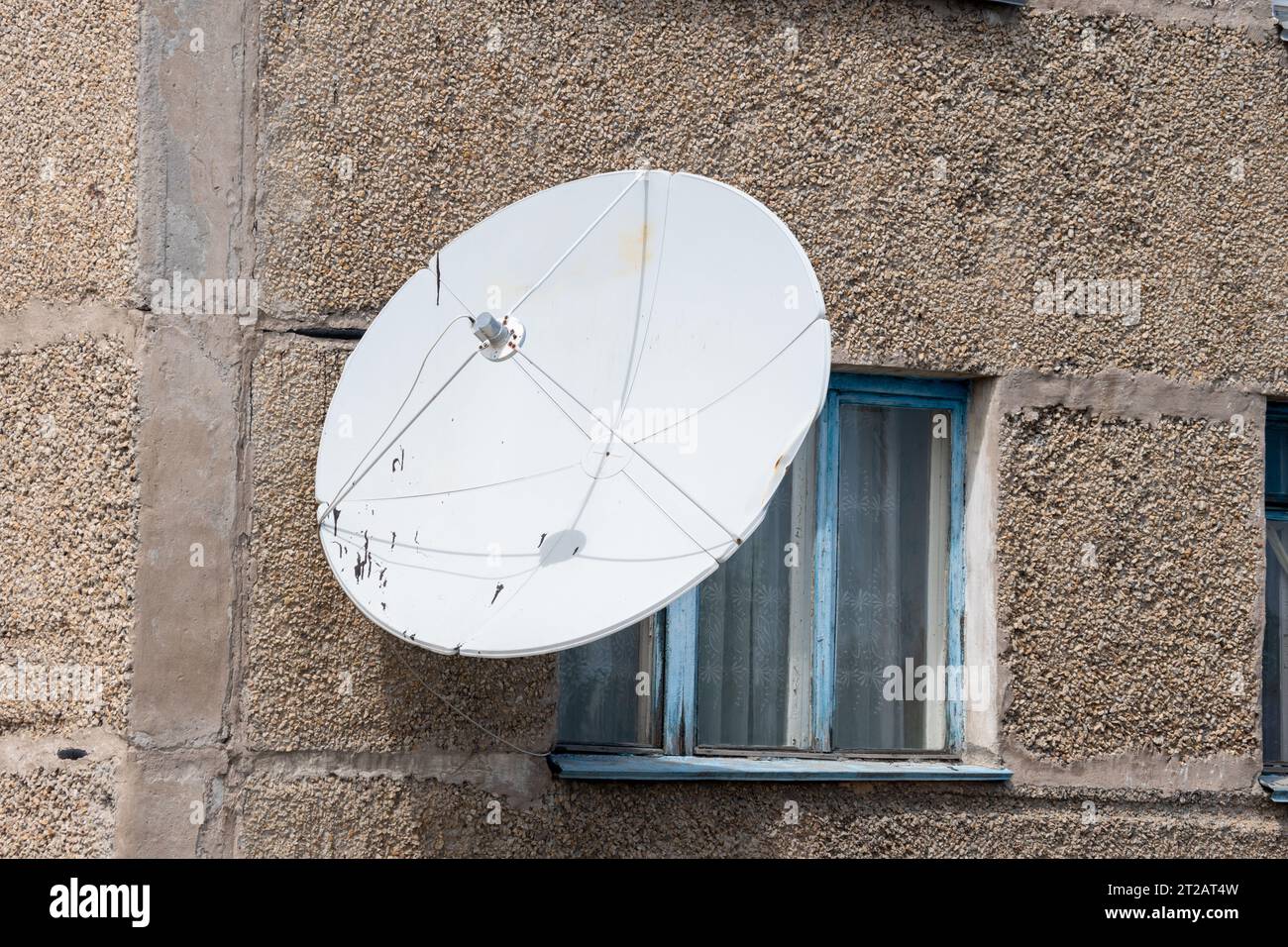 Antenne TV satellite sur le mur de la maison. Récepteur d'antenne rond blanc pour signal radio. Antenne de ville pour télévision, radio, Internet. Banque D'Images