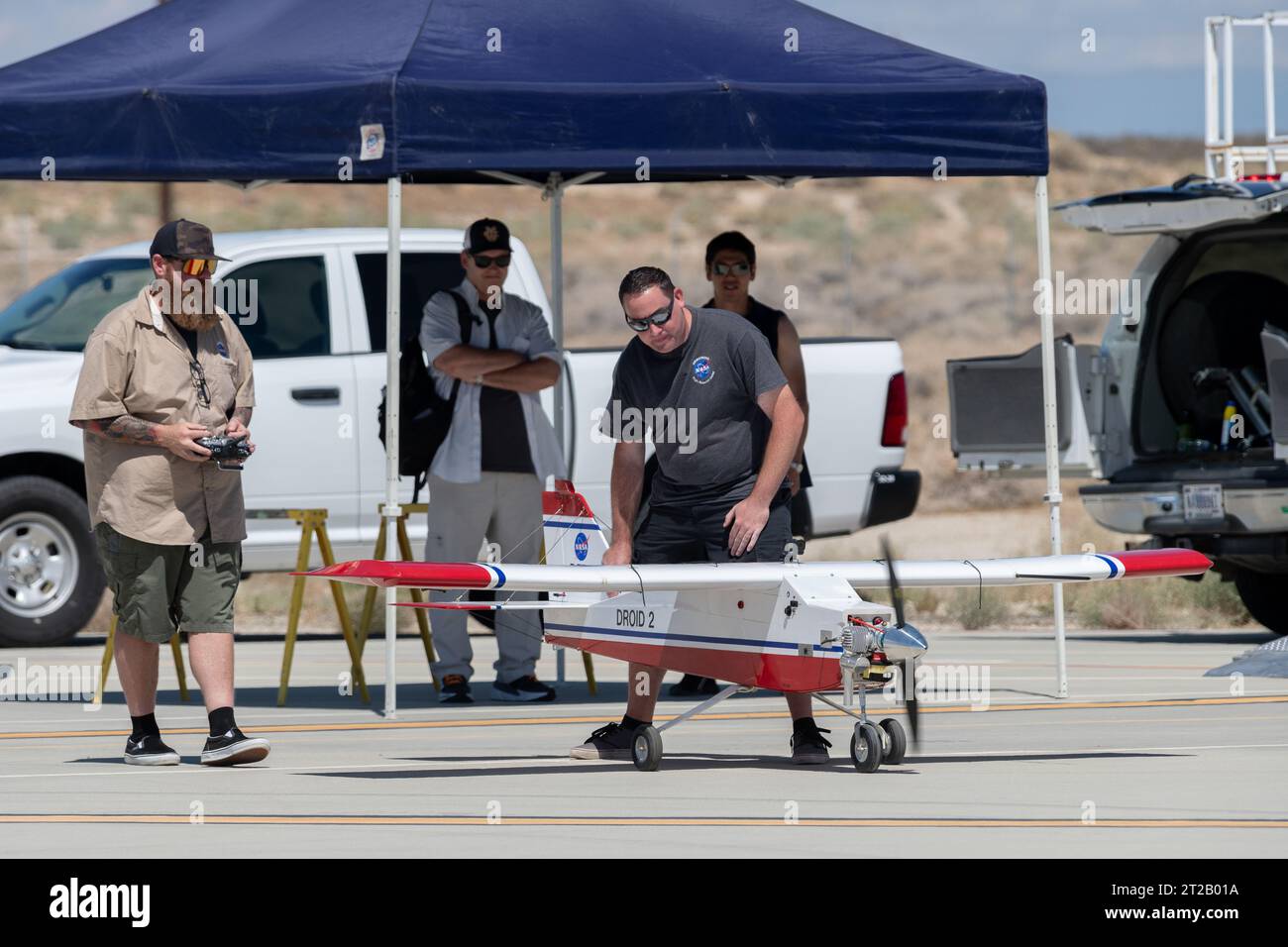 . Justin Hall, à gauche, se prépare à piloter le DROID 2 (Dryden Remote Operated Integrated Drone 2), alors que John Melton regarde et Justin Link effectue un dernier ajustement. Le vol faisait partie de la campagne Advanced exploration of Reliable Operation at Low altitudes : Meteorology, Simulation, and Technology. L'étude météorologique a été réalisée au Armstrong Flight Research Center de la NASA à Edwards, en Californie. L'objectif était d'étudier le vent afin de fournir des données pour le décollage et l'atterrissage en toute sécurité des futurs taxis aériens. Banque D'Images