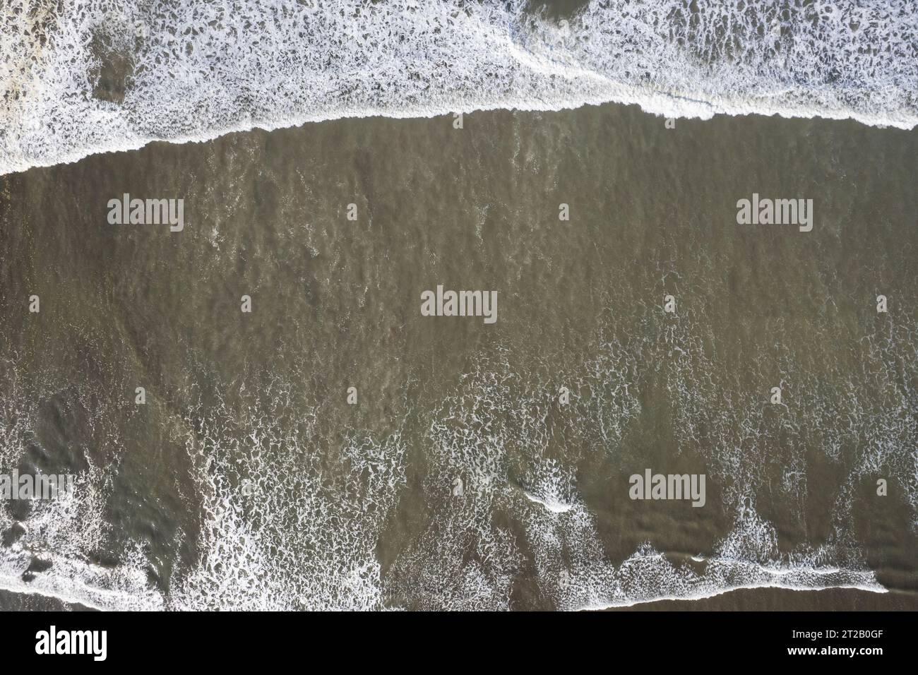 Vagues de crash sur la rive au-dessus de la texture de vue de drone supérieur Banque D'Images