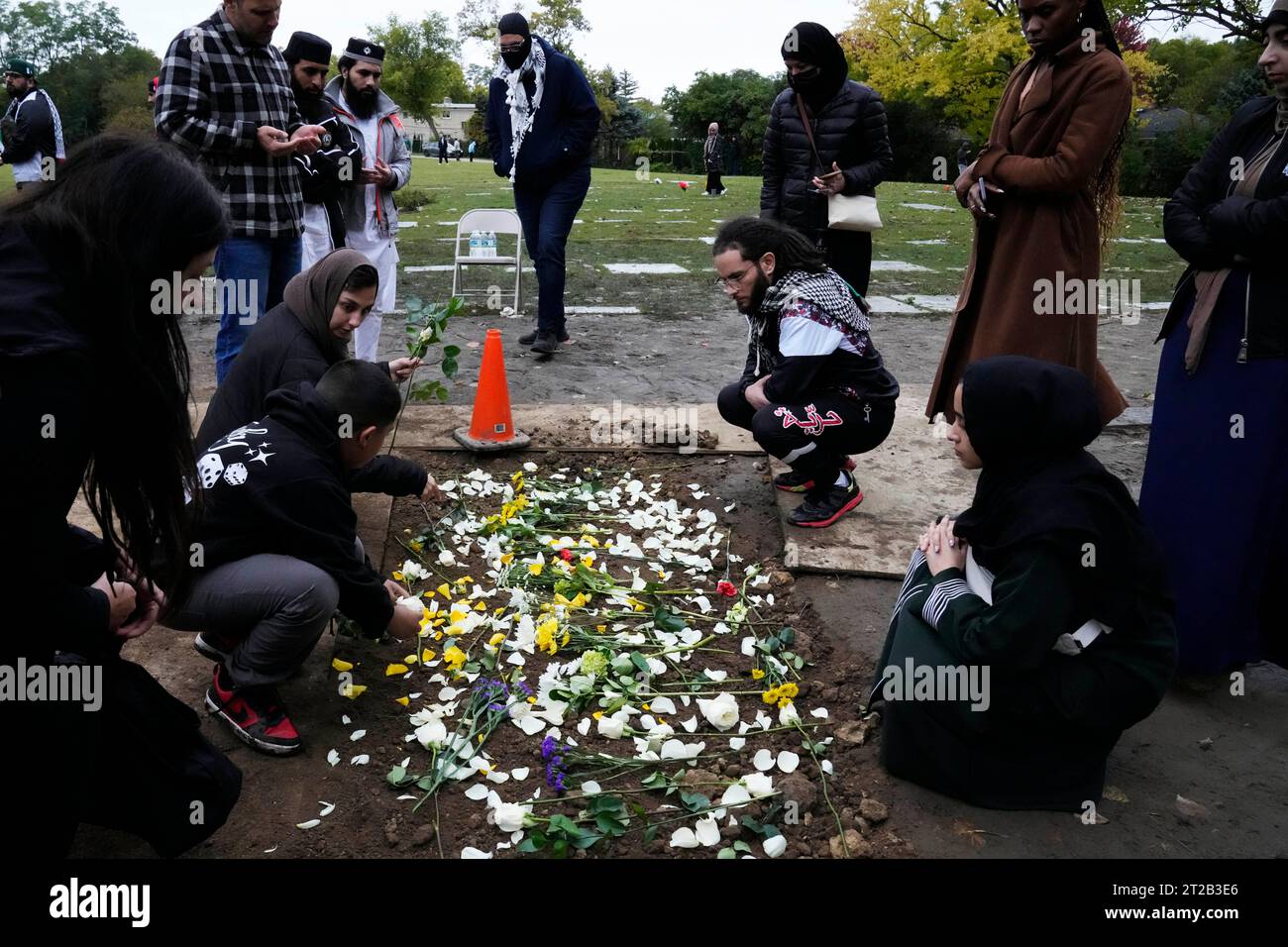 Muslim community members leave flowers at Wadea Al Fayoume's grave in LaGrange, Ill., Monday, Oct. 16, 2023. An Illinois landlord accused of fatally stabbing the 6-year-old Muslim boy and seriously wounding his mother was charged with a hate crime after police and relatives said he singled out the victims because of their faith and as a response to the war between Israel and Hamas. (AP Photo/Nam Y. Huh6 Banque D'Images