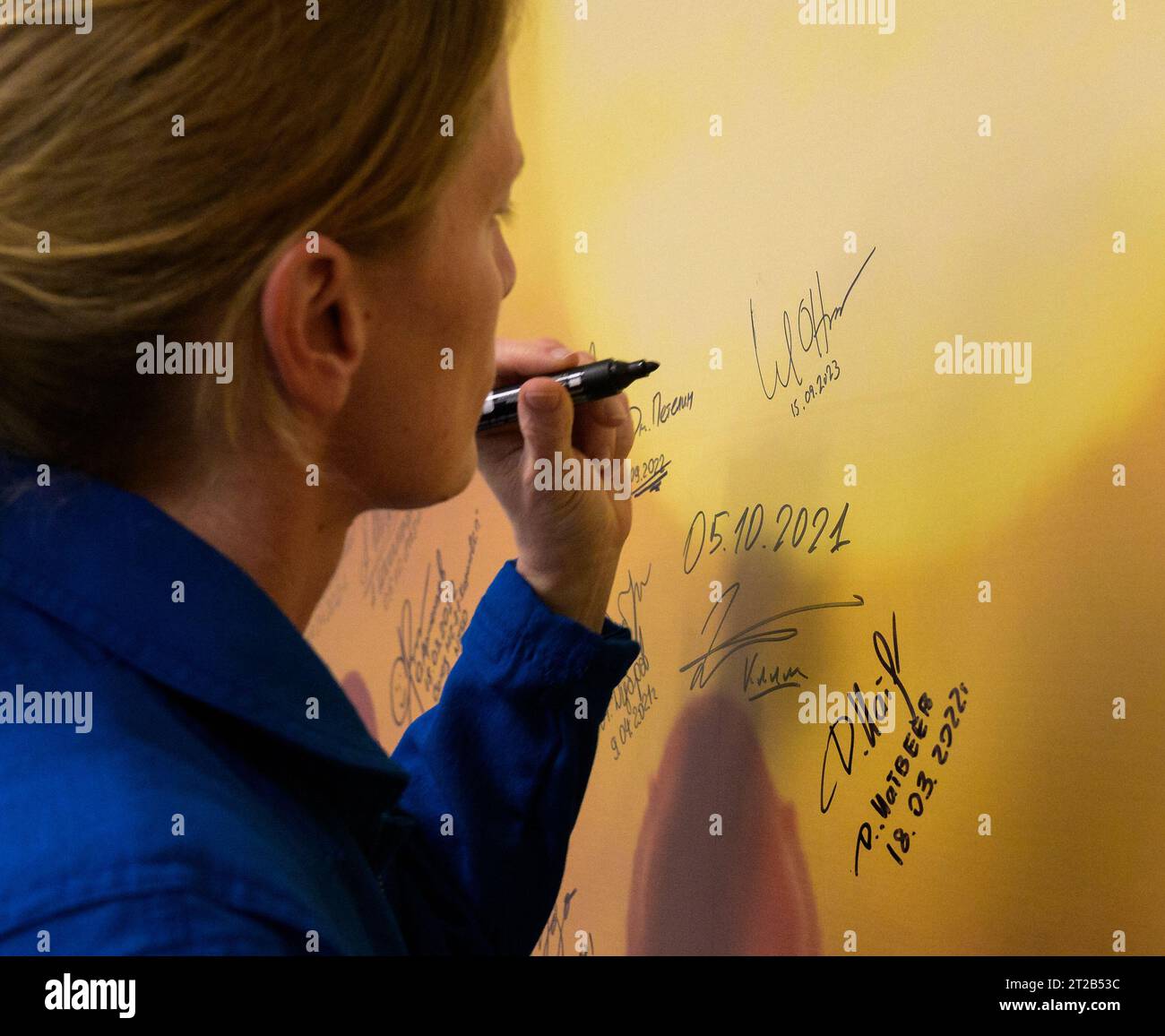 L'astronaute de la NASA Loral O'Hara signe une fresque murale à l'hôtel Cosmonaut à Baïkonour, Kazakhstan, le 15 septembre 2023, avant de partir avec les cosmonautes de Roscosmos Oleg Kononenko et Nikolai Chub pour leur lancement Soyouz vers la Station spatiale internationale pour l'expédition 70. Banque D'Images