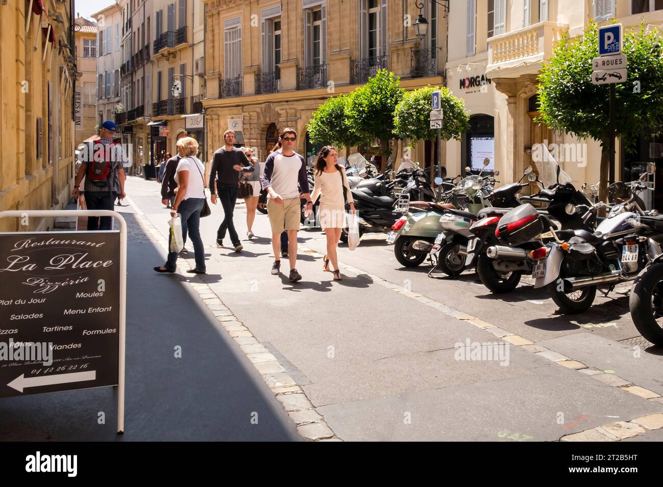 Personnes marchant le long d'une rue de la vieille ville, Aix-en-Provence, sud de la France. Banque D'Images