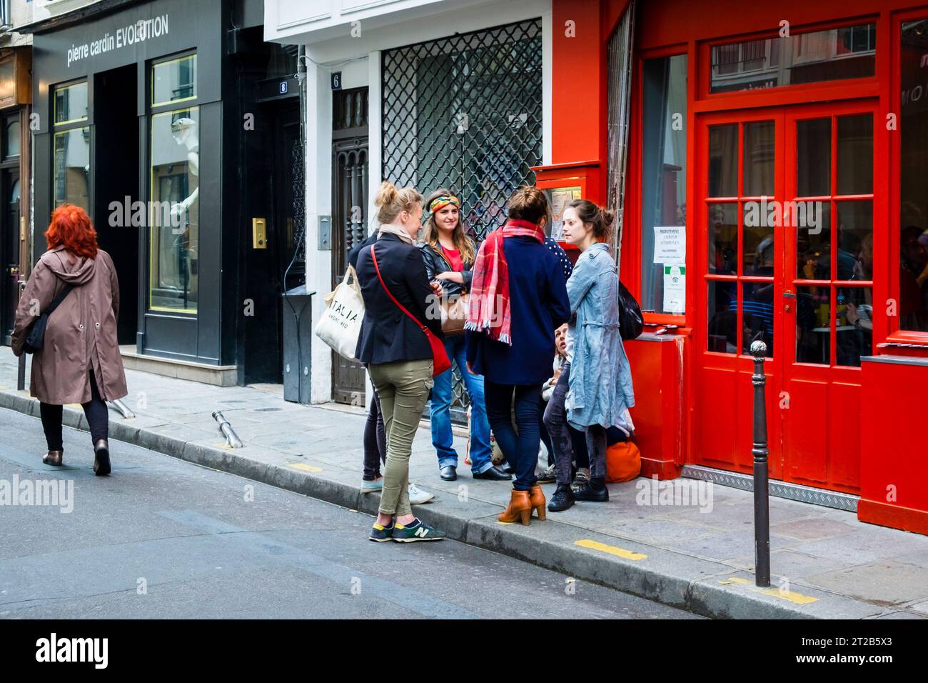 Un groupe de jeunes femmes adultes se rassemble dans une rue du quartier du Marais, Paris, France. Banque D'Images