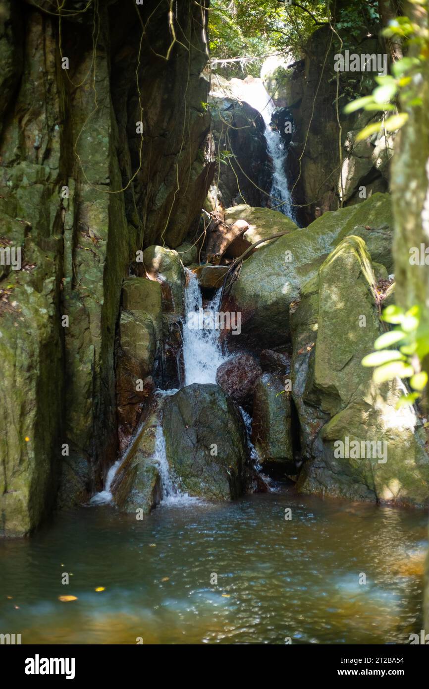 Cascade à plusieurs niveaux en pierres dans la forêt tropicale de Thaïlande. Paysage vertical. Banque D'Images