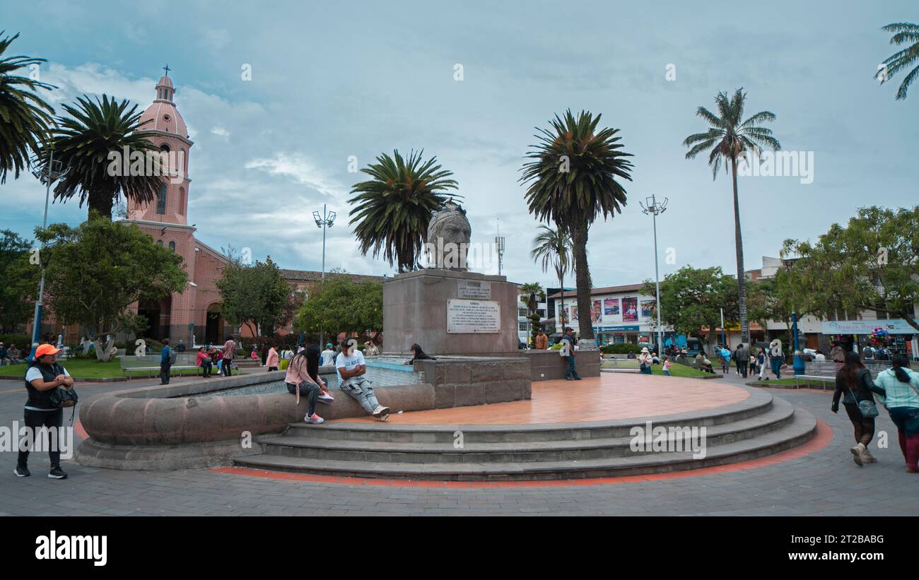 Otavalo, Imbabura / Équateur - octobre 14 2023 : les gens marchent devant le monument Ruminahui dans le parc central d'Otavalo avec la cathédrale Banque D'Images