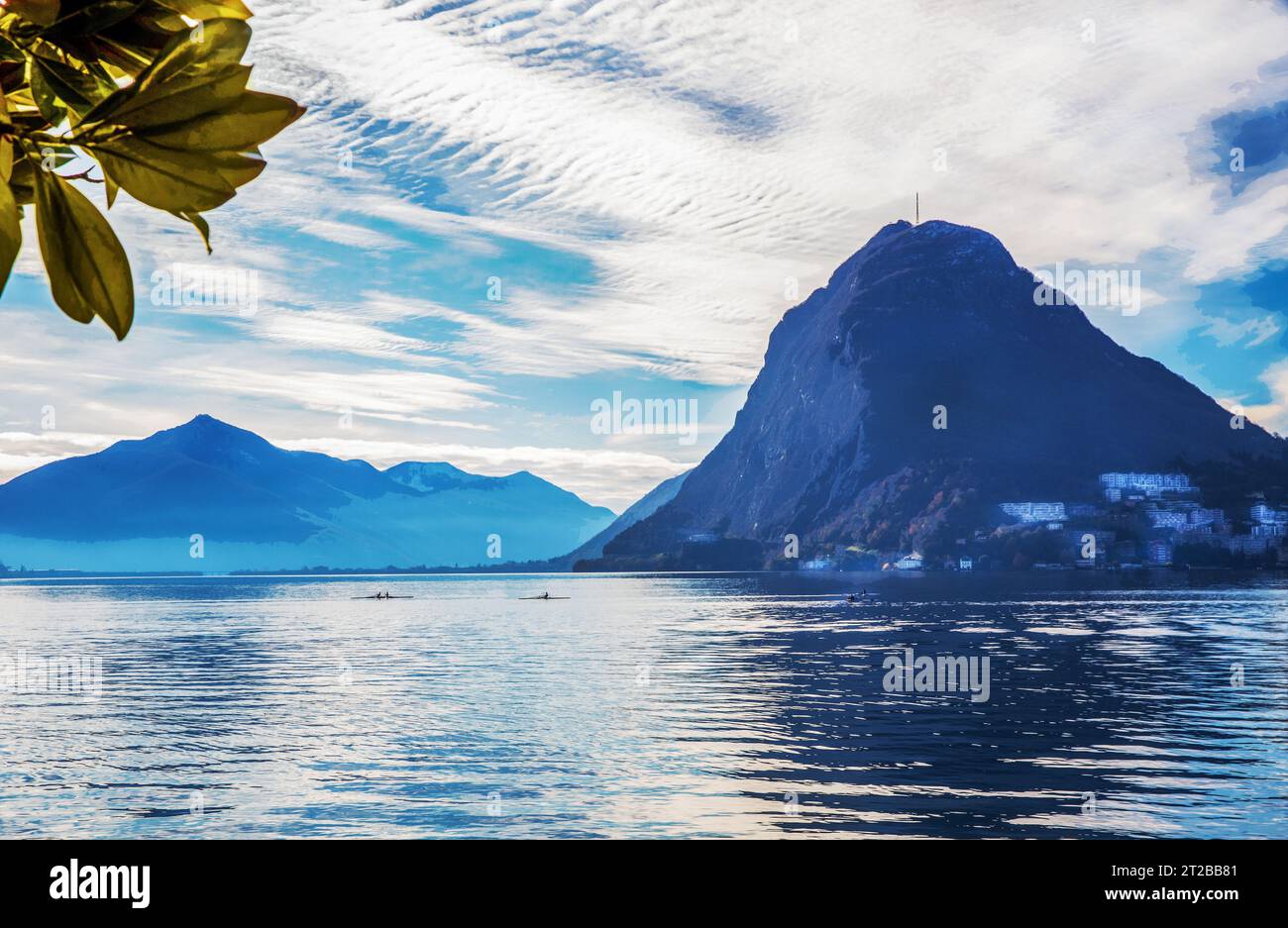 Superbe panorama sur le lac de Lugano, les Alpes suisses et 4 kayaks se déplace dans l'eau (un - pour 2 personnes) personnes méconnaissables dans la distance dans le paysage suisse ensoleillé Banque D'Images