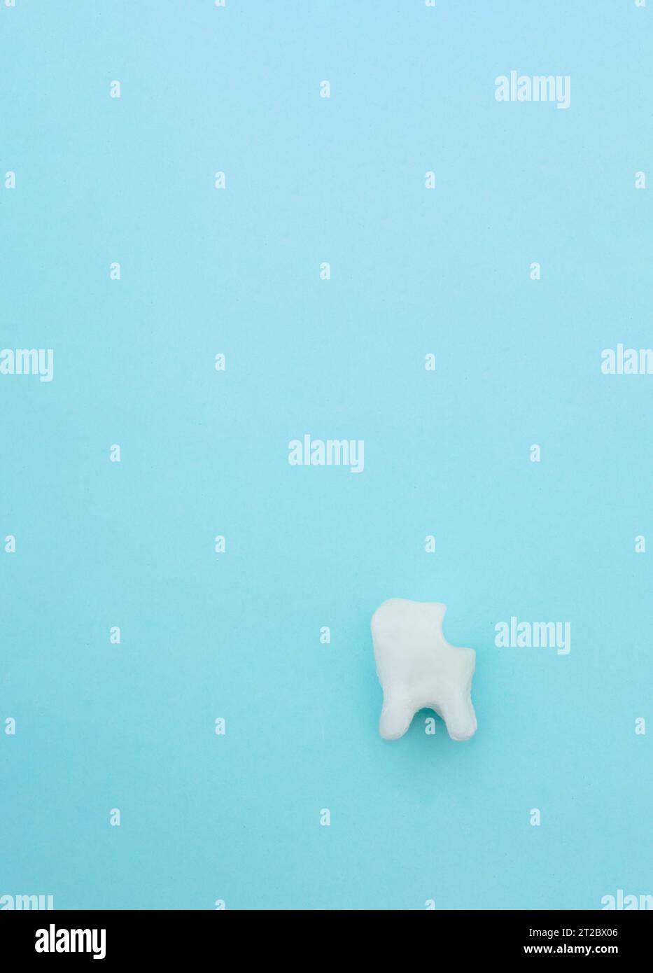 Modèle molaire blanc de dent malsain sur fond bleu pastel. Symbole de dent. Caries. Caries et maladie de la dent. Dents malsaines. La dentisterie concep Banque D'Images