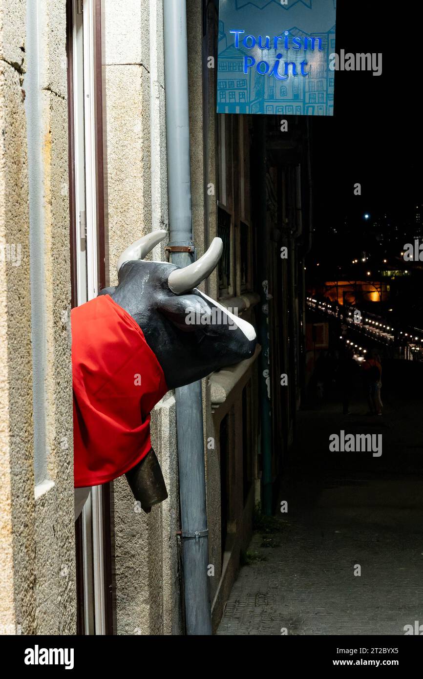 Statue de taureau dans la cape rouge devant le bureau d'information touristique la nuit Banque D'Images